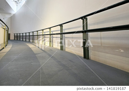 Modern curved ramp with metal handrail and glass railing. Modern curved ramp with metal handrail and glass railing. 141819187