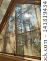 Cozy tent interior with quilted sleeping pad, mesh window, sunrise over pine forest, warm golden light filtering through fabric walls and soft morning shadows across camp bed 141819434