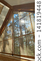 Cozy tent interior with quilted sleeping pad, mesh window, sunrise over pine forest, warm golden light filtering through fabric walls and soft morning shadows across camp bed 141819448