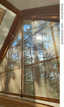 Cozy tent interior with quilted sleeping pad, mesh window, sunrise over pine forest, warm golden light filtering through fabric walls and soft morning shadows across camp bed Cozy tent interior with quilted sleeping pad, mesh window, sunrise over pine forest, warm golden light filtering through fabric walls and soft morning shadows across camp bed 141819448
