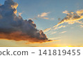 A colorful, dramatic sky featuring purple and gold clouds at sunset 141819455