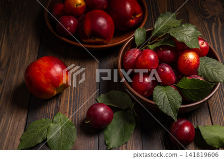 Fresh plums and nectarine on rustic wooden table Fresh plums and nectarine on rustic wooden table 141819606