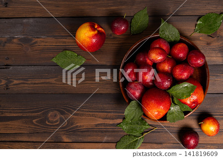 Fresh plums and nectarines in bowl on rustic wood Fresh plums and nectarines in bowl on rustic wood 141819609