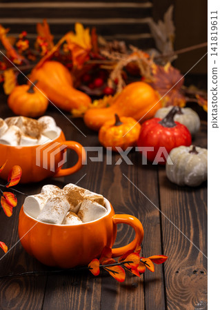 Cozy autumn drink with marshmallows and pumpkins Cozy autumn drink with marshmallows and pumpkins 141819611