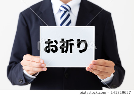 A young businessman in a business suit holding a whiteboard with a prayer written on it. A young businessman in a business suit holding a whiteboard with a prayer written on it. 141819637