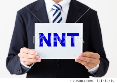 A young businessman in a business suit holding a whiteboard with "NNT" written on it. A young businessman in a business suit holding a whiteboard with "NNT" written on it. 141819719