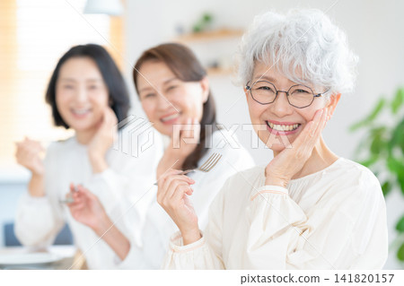 一位老婦人和她的朋友在家吃午餐 141820157