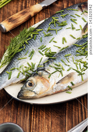Fresh salted herring with herbs on plate Fresh salted herring with herbs on plate 141820342