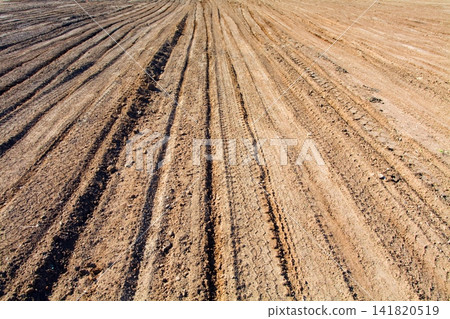 Texture brown yellow clay earth with traces of cars, trucks, tractors. Road with tire tracks. Texture brown yellow clay earth with traces of cars, trucks, tractors. Road with tire tracks. 141820519