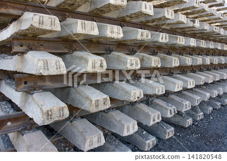 Rusty intermediate rail fasteners on concrete sleepers for train and tram, laying railroad tracks Rusty intermediate rail fasteners on concrete sleepers for train and tram, laying railroad tracks 141820548