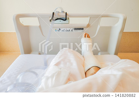 A foot in a cast resting in a hospital bed after surgery for a ruptured Achilles tendon. A foot in a cast resting in a hospital bed after surgery for a ruptured Achilles tendon. 141820882