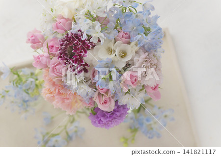 A bouquet of pale pink and light blue flowers stands out beautifully against a white background (viewed from directly above). A bouquet of pale pink and light blue flowers stands out beautifully against a white background (viewed from directly above). 141821117