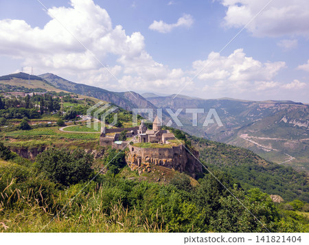 Monastery ruins atop steep hill with surrounding forested mountains Monastery ruins atop steep hill with surrounding forested mountains 141821404