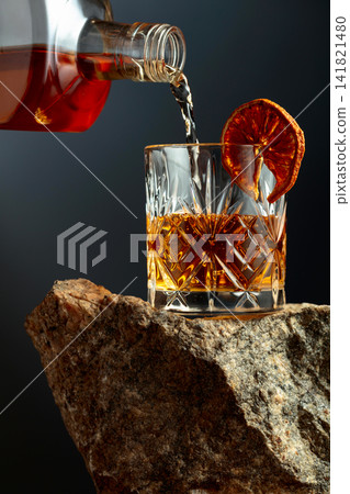 Old-fashoned cocktail on a rough granite. Old-fashoned cocktail on a rough granite. 141821480