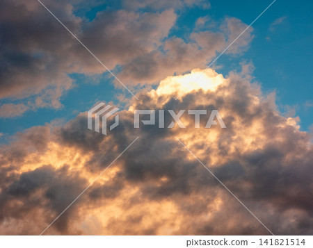 Dramatic sky scene with glowing clouds illuminated by sunrise or sunset 141821514