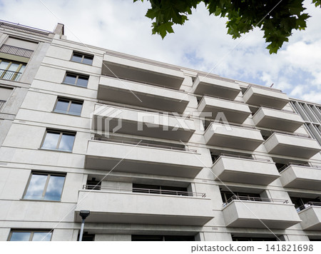Low angle view of modern residential apartment building facade with balconies. Low angle view of modern residential apartment building facade with balconies. 141821698