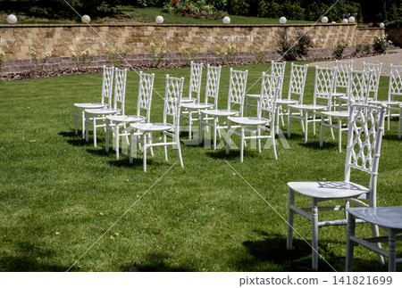 Empty white folding chairs arranged in rows Empty white folding chairs arranged in rows 141821699