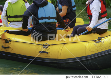一艘漂流船順流而下,船上的乘客們也參與其中。 一艘漂流船順流而下,船上的乘客們也參與其中。 141821902