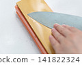 A woman's hands sharpening a knife 141822324