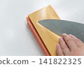 A woman's hands sharpening a knife 141822325