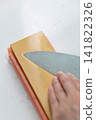 A woman's hands sharpening a knife 141822326