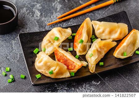Dumplings served on a plate with green onions Dumplings served on a plate with green onions 141822507
