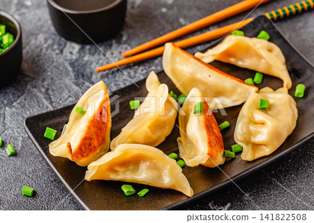 Dumplings served on a plate with green onions Dumplings served on a plate with green onions 141822508