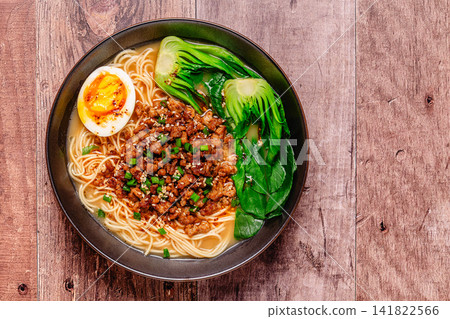 A bowl of noodles with minced meat, egg, and bok choy. A bowl of noodles with minced meat, egg, and bok choy. 141822566