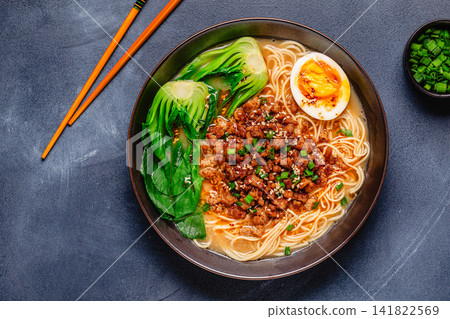 A bowl of noodles with minced meat, egg, and bok choy. A bowl of noodles with minced meat, egg, and bok choy. 141822569