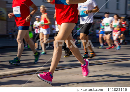 Female runner in foreground of large crowd Female runner in foreground of large crowd 141823136