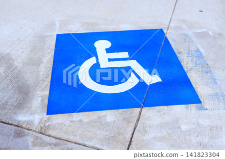 Sign shows blue background with white symbol representing person in wheelchair. Sign shows blue background with white symbol representing person in wheelchair. 141823304