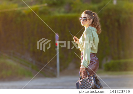 Confident Stylish Woman Looking Over Shoulder in the City 141823759