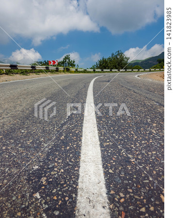 Winding country road leads through scenic landscape Winding country road leads through scenic landscape 141823985