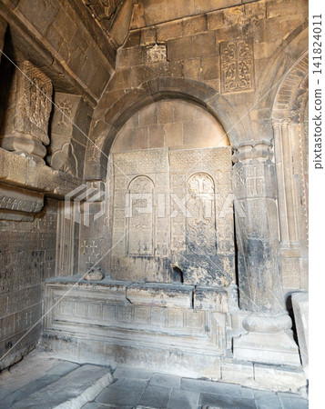 Weathered stone chapel featuring intricate carvings and arched entry Weathered stone chapel featuring intricate carvings and arched entry 141824011