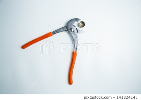 Close-up of the adjustable large wrench is open and between its teeth lies a pipe plug lying on a white background in the center. The concept of repair, plumbing, settings. High quality photo Close-up of the adjustable large wrench is open and between its teeth lies a pipe plug lying on a white background in the center. The concept of repair, plumbing, settings. High quality photo 141824143