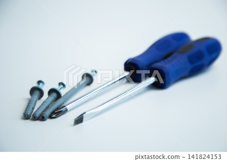 Close-up of two hands in work gloves holding screwdrivers against a white background. Concept of repair, handyman, tools, construction, installation. High quality photo Close-up of two hands in work gloves holding screwdrivers against a white background. Concept of repair, handyman, tools, construction, installation. High quality photo 141824153