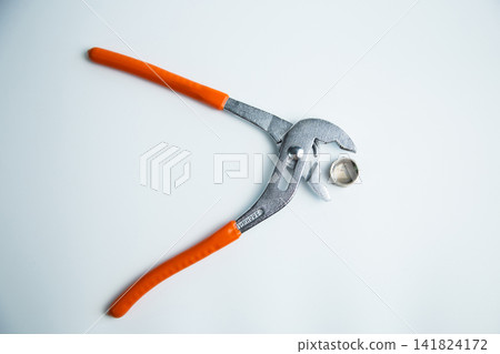 Close-up of the adjustable large wrench is open and between its teeth lies a pipe plug lying on a white background in the center. The concept of repair, plumbing, settings. High quality photo Close-up of the adjustable large wrench is open and between its teeth lies a pipe plug lying on a white background in the center. The concept of repair, plumbing, settings. High quality photo 141824172