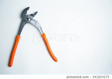 Close-up of an adjustable large wrench lies on a white background on the side with space for text. The concept of repair, plumbing, settings. High quality photo Close-up of an adjustable large wrench lies on a white background on the side with space for text. The concept of repair, plumbing, settings. High quality photo 141824173