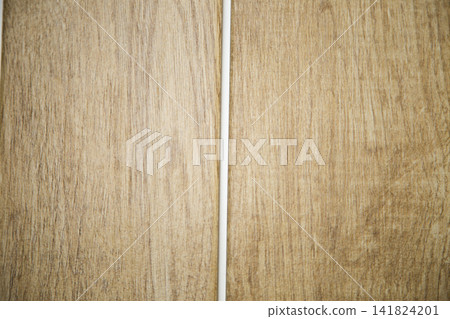 Wood-coloured porcelain stoneware tiles lie apart with a white vertical joint in between, showing the tiling and grouting. The concept of choosing and laying tiles, repairs, interior decoration Wood-coloured porcelain stoneware tiles lie apart with a white vertical joint in between, showing the tiling and grouting. The concept of choosing and laying tiles, repairs, interior decoration 141824201