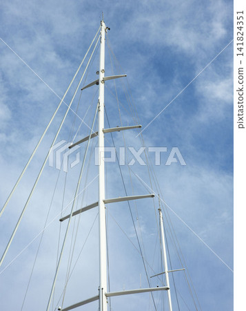 Abstract geometric detail of a white yacht mast with rigging against a blue sky Abstract geometric detail of a white yacht mast with rigging against a blue sky 141824351