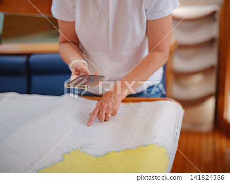 Woman Sailor Studying Navigation Map Inside Yacht Cabin Interior Woman Sailor Studying Navigation Map Inside Yacht Cabin Interior 141824386
