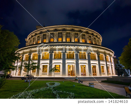 Beautiful, illuminated opera building at night with garden and statue Beautiful, illuminated opera building at night with garden and statue 141824610