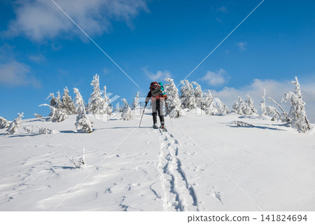 Man hiking on snow in mountains Man hiking on snow in mountains 141824694