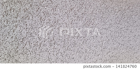 High angle close up of an uneven gray surface densely covered with small granular bumps, creating a dry, coarse, slightly porous texture. High angle close up of an uneven gray surface densely covered with small granular bumps, creating a dry, coarse, slightly porous texture. 141824760