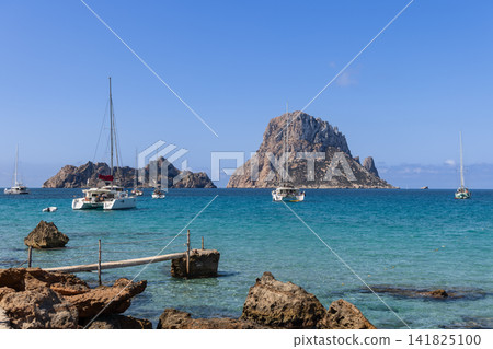 Es Vedra and Es Vedranell seen off Cala d Hort with sailboats and catamarans. Es Vedra and Es Vedranell seen off Cala d Hort with sailboats and catamarans. 141825100