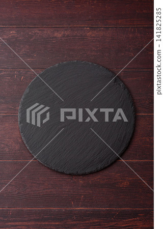 An empty black slate kitchen board for food preparation. An empty slate board serving An empty black slate kitchen board for food preparation. An empty slate board serving 141825285