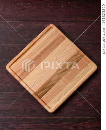 A square wooden cutting board for home food preparation. A wooden cutting board A square wooden cutting board for home food preparation. A wooden cutting board 141825290