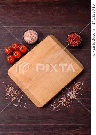 A square wooden cutting board for home food preparation. A wooden cutting board 141825310