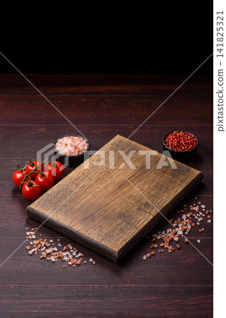 A square wooden cutting board for home food preparation. A wooden cutting board A square wooden cutting board for home food preparation. A wooden cutting board 141825321