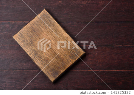 A square wooden cutting board for home food preparation. A wooden cutting board A square wooden cutting board for home food preparation. A wooden cutting board 141825322